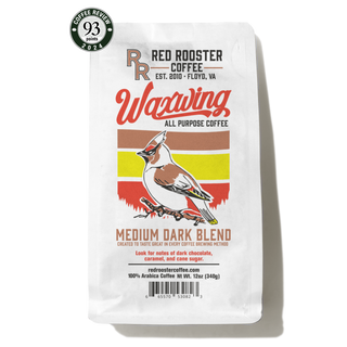 Waxwing All-Purpose Blend bag with bold label and a green coffee cup on a yellow saucer
