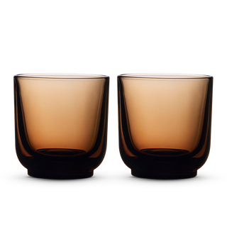 Two amber Fellow Pirch espresso shot glasses on a black background