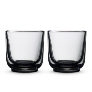 Two clear Fellow Pirch espresso shot glasses on a black background