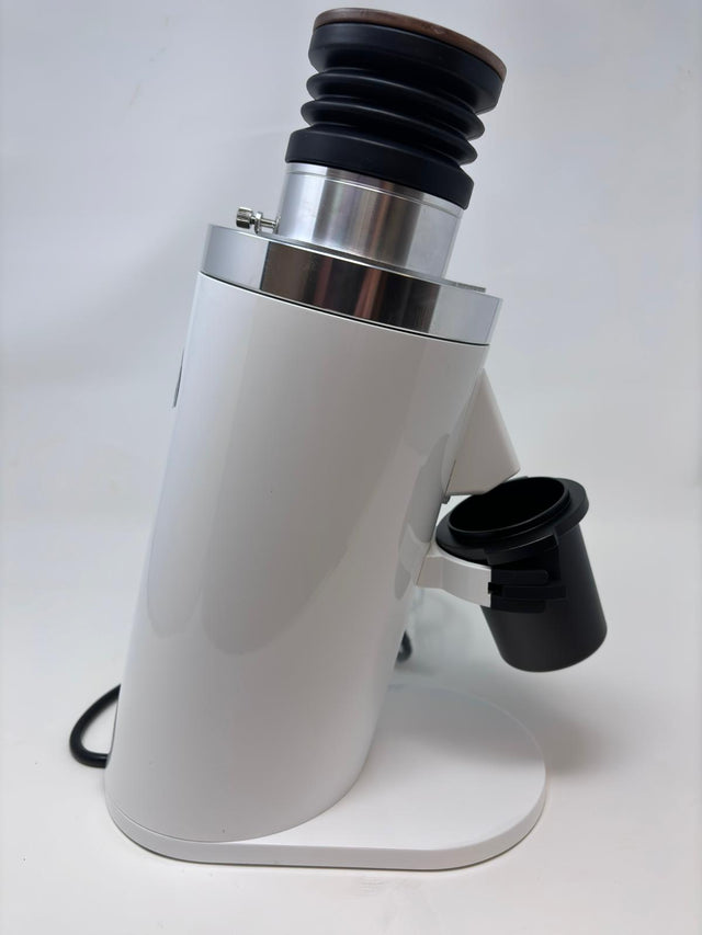 Side view of Turin DF64 Gen 2.5 single dose coffee grinder with white body chrome band and black accordion hopper; power cord visible.