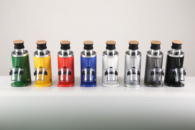 Row of Turin DF64 Gen 2.5 single dose coffee grinders in green yellow red blue white silver gray and black lined up on a white surface