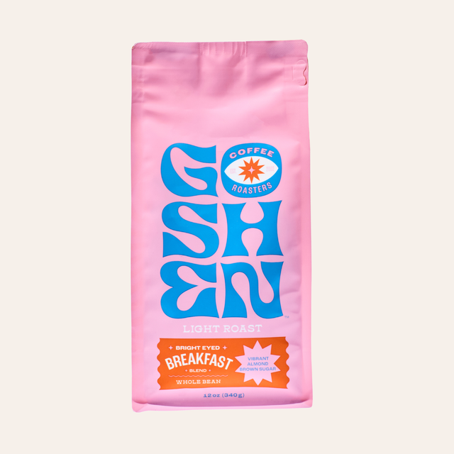 Pink Bright Eyed Breakfast coffee bag with blue decorative artwork and Goshen Roasters logo