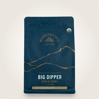 Dark blue Big Dipper coffee bag with gold emblem and USDA Organic badge, a dark roast label.