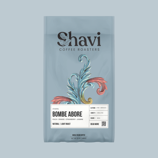Blue coffee bag featuring the Shavi Coffee Roasters logo and a botanical illustration