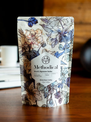 Floral patterned Methodical Brazil Signature Series coffee bag on a wooden table