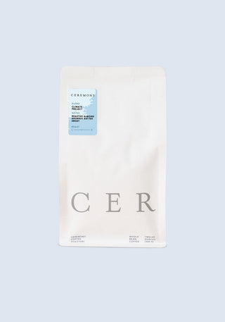 Climate Project coffee bag from Ceremony Roasters with a light blue label on a white pouch set against pale blue.