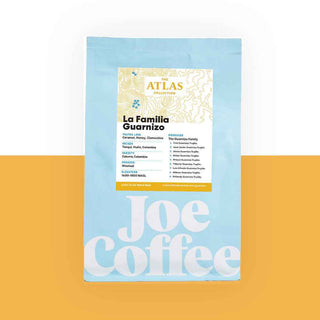 Blue coffee bag labeled La Familia Guarnizo Atlas Collection on an orange background