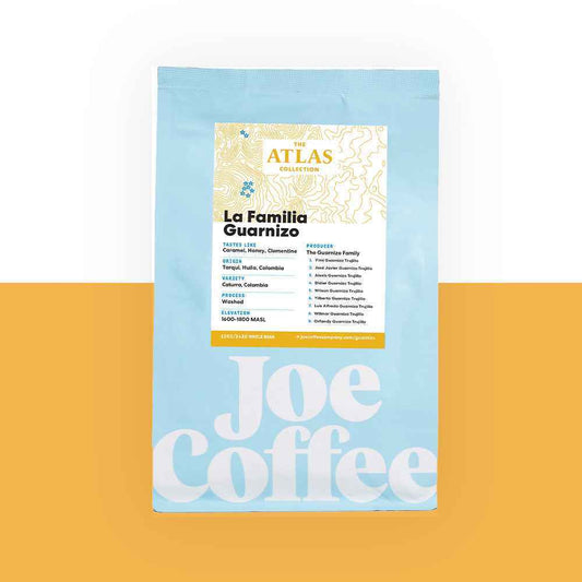 Blue coffee bag labeled La Familia Guarnizo Atlas Collection on an orange background