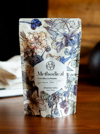 Floral patterned Methodical Costa Rica La Pastora coffee bag on a wooden table