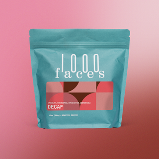 Teal 1000 Faces Decaf coffee bag on a pink gradient backdrop with a red geometric label and DECAF.