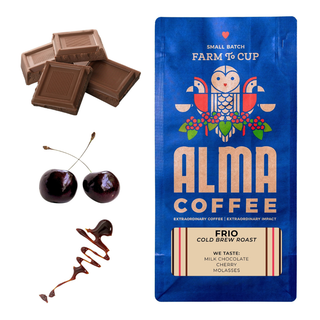 Milk chocolate squares and fresh cherries beside a blue Alma Coffee Frio cold brew roast bag