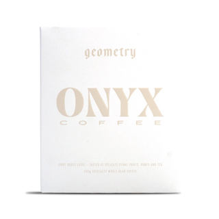 White Onyx Geometry coffee box with pale gold typography across the front