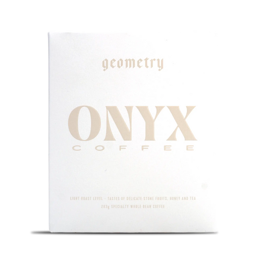 White Onyx Geometry coffee box with pale gold typography across the front