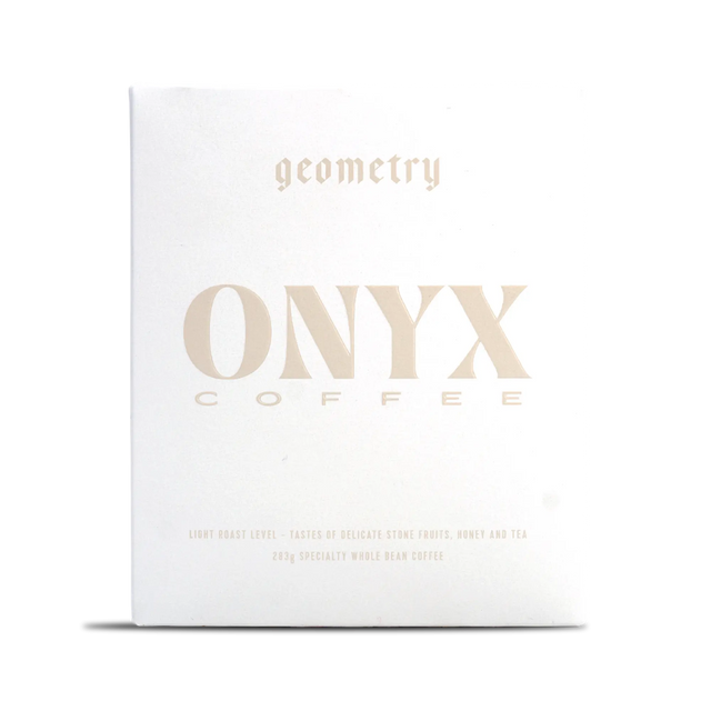 White Onyx Geometry coffee box with pale gold typography across the front