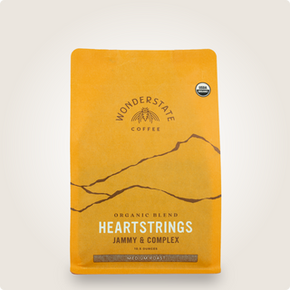 Top portion of orange Organic Heartstrings coffee bag from Wonderstate with USDA Organic badge