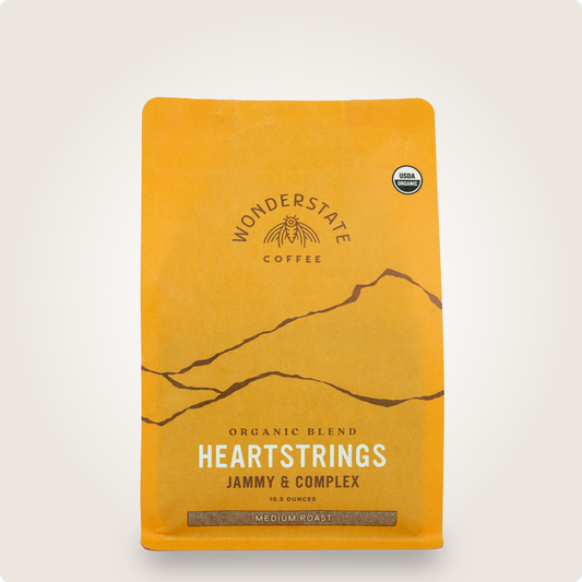 Top portion of orange Organic Heartstrings coffee bag from Wonderstate with USDA Organic badge