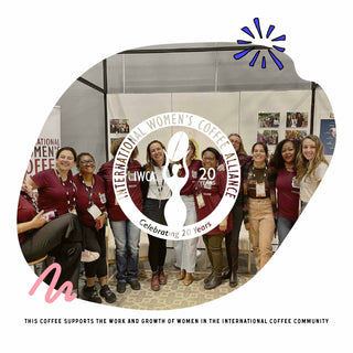 Group of women in maroon shirts posing at a coffee event with an International Women's Coffee Alliance logo overlay