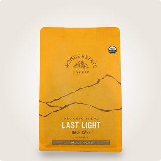 Orange Last Light Half Caff coffee bag with USDA Organic badge.