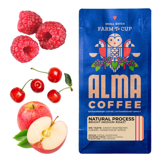 Raspberries cherries and a sliced apple next to a blue Alma Coffee Natural Process bag