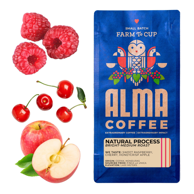 Raspberries cherries and a sliced apple next to a blue Alma Coffee Natural Process bag