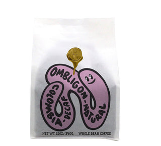 Colombia Ombligon Decaf natural coffee bag featuring a purple abstract worm shaped creature.