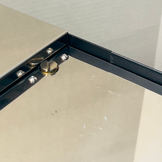 Close up of the metal hinge and screws on the open box Profitec GO espresso machine.