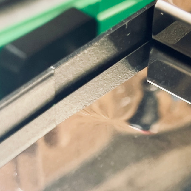 Close-up of a Profitec GO espresso machine frame with a bright green edge.