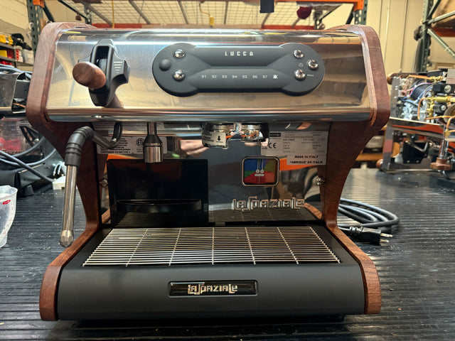 Front view of a LUCCA A53 Mini Bubinga espresso machine with chrome body and wood trim, portafilter on the left.