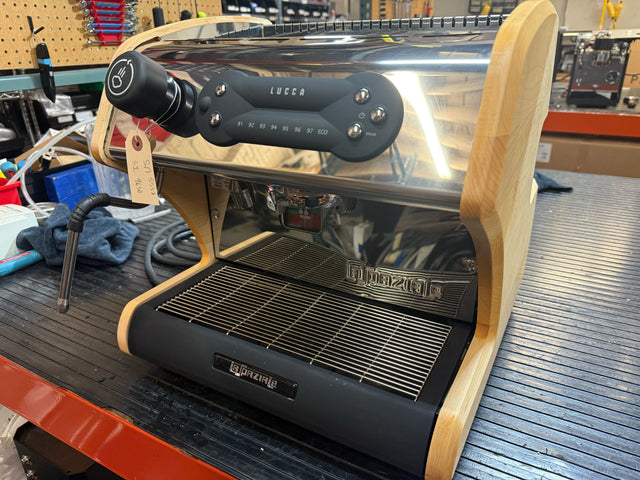 Close up view of Lucca A53 DP Maple espresso machine control panel mounted on a wooden housing