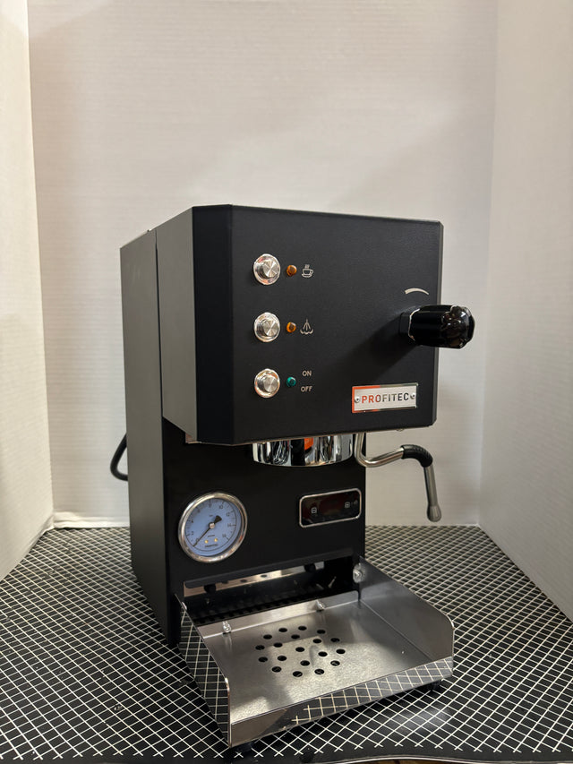 Open box Profitec GO espresso machine front panel with chrome knobs and orange indicator lights.