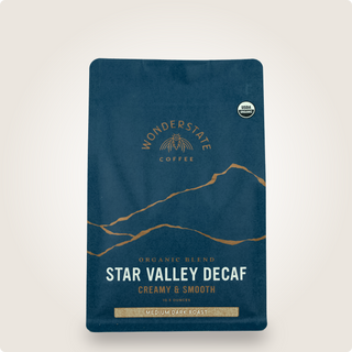 Close up of a dark blue Organic Star Valley Decaf coffee bag with a USDA Organic seal and mountain graphic.