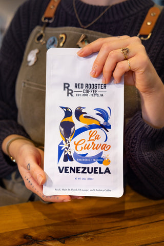 Close up of Venezuela La Curva coffee bag showing Anaerobic Washed label and colorful bird artwork