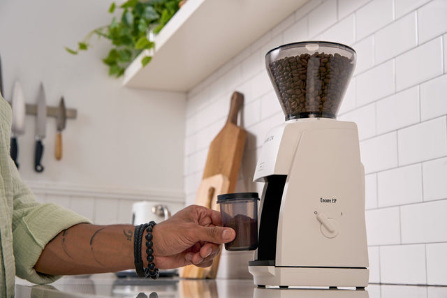 Baratza Encore ESP Espresso Grinder, from Clive Coffee, hand holding dosing cup, lifestyle