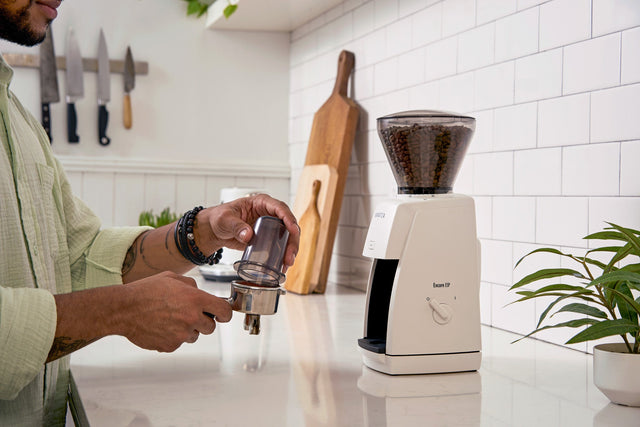 Baratza Encore ESP Espresso Grinder, from Clive Coffee, person holding dosing cup and portafilter, lifestyle