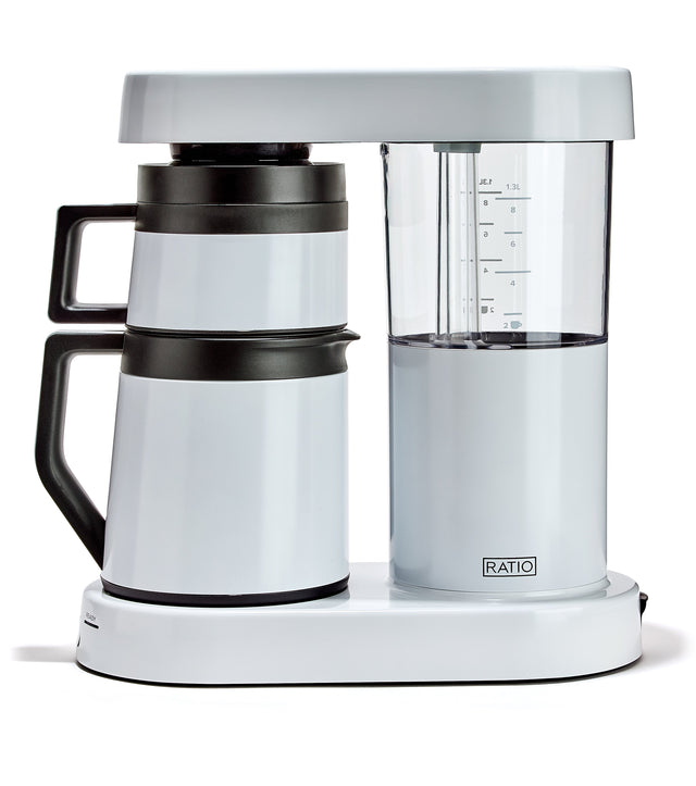 Ratio Six White coffee maker with dual carafes on a white base, white vessel with a black handle and a clear glass reservoir